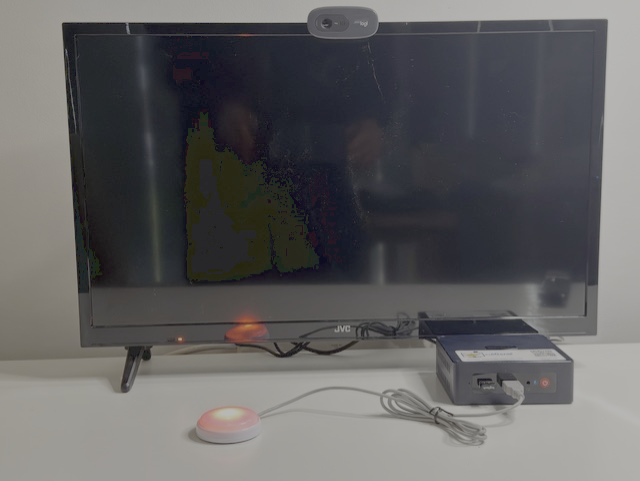 CallGenie device attached to television with the Do Not Disturb button activated.  The button has ared light on the television screen is black turned off.