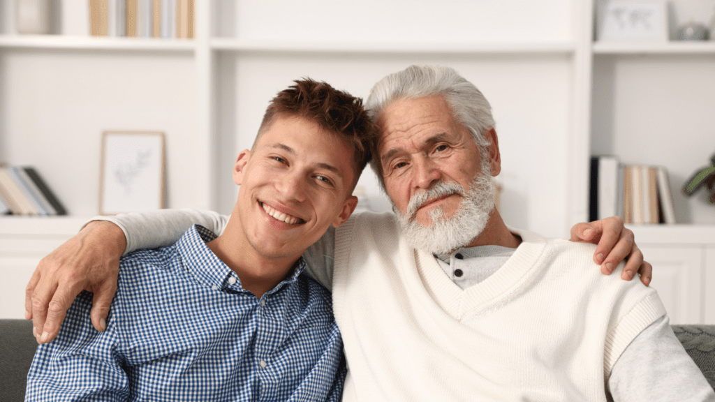 Older man and younger man sitting next to each other with arm around each others shoulders. A representation of both Sam and Jeff in the story as two family members. Sam the Father and Jeff the son